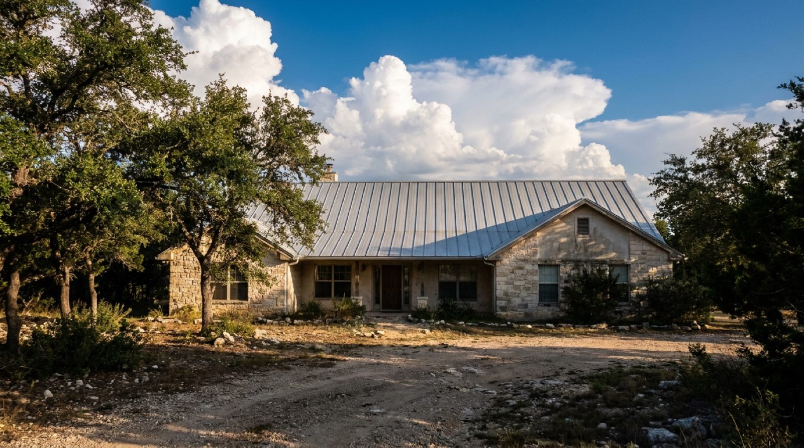Bare Galvalume standing seam metal roof on a limestone Hill Country home outside San Antonio